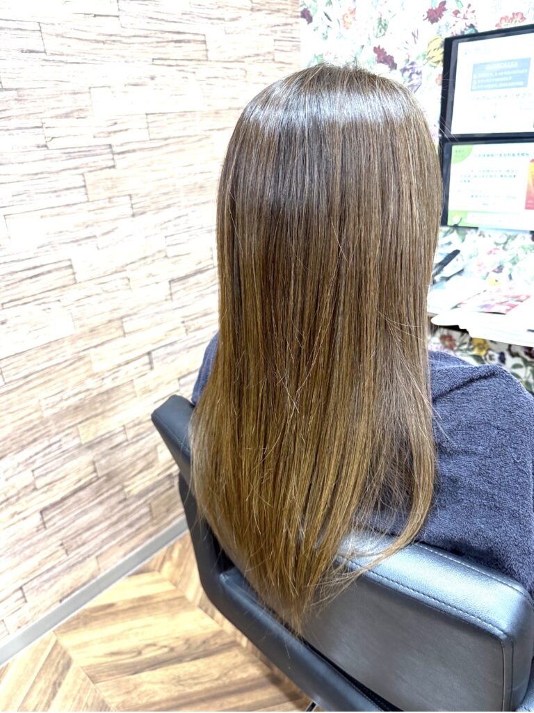 明るい白髪染めで透明感を出した、ツヤのあるロングヘアの大人カラー